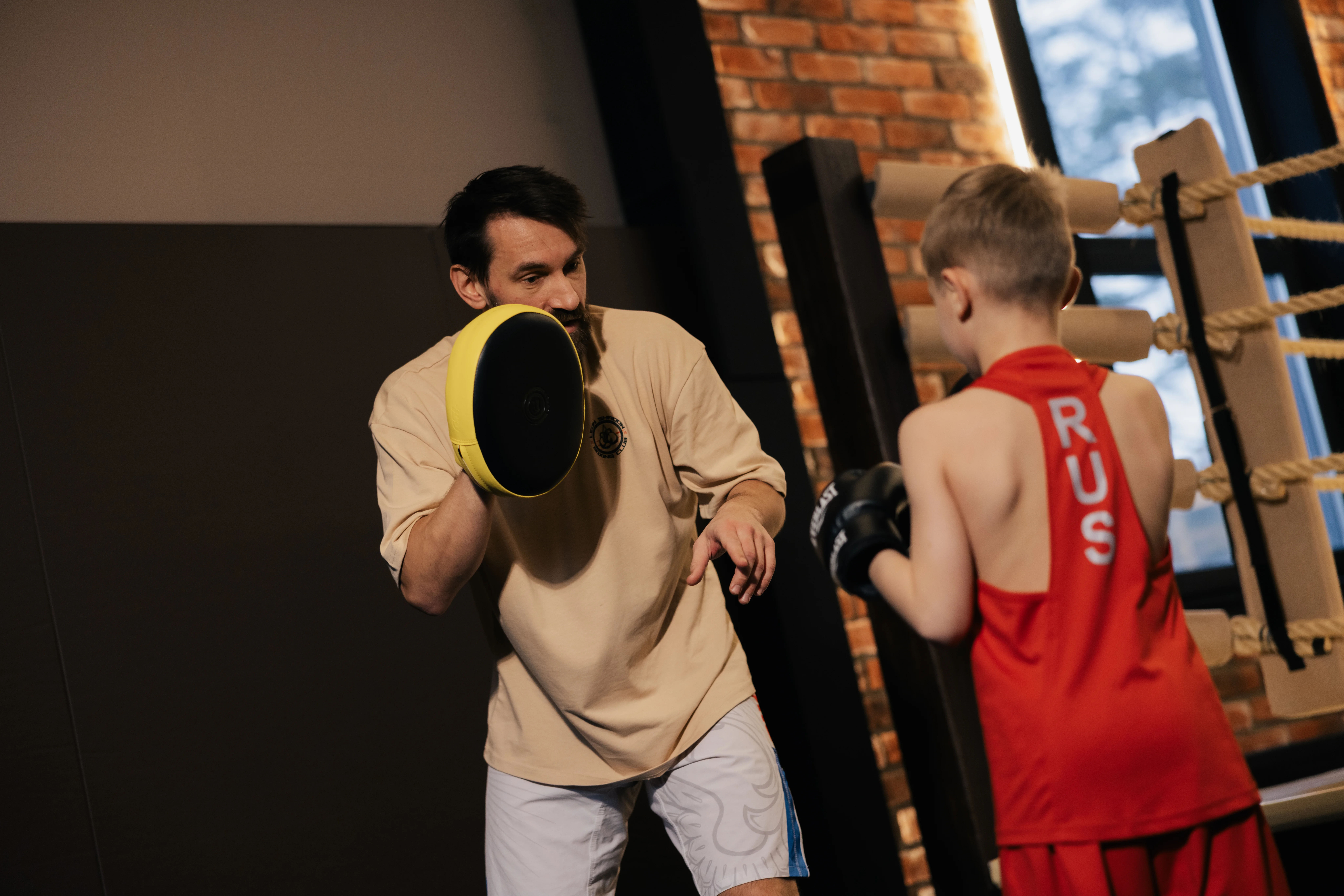 Дети занимаются боксом в группе под руководством тренера в клубе Leon Shadow